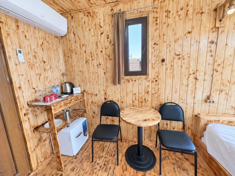 Glass cabin interior: table, kettle, mini fridge, air conditioning — Nika Hotel & Club