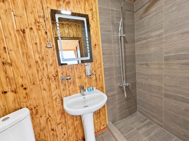 Glass cabin bathroom with shower, sink and illuminated mirror — Nika Hotel & Club